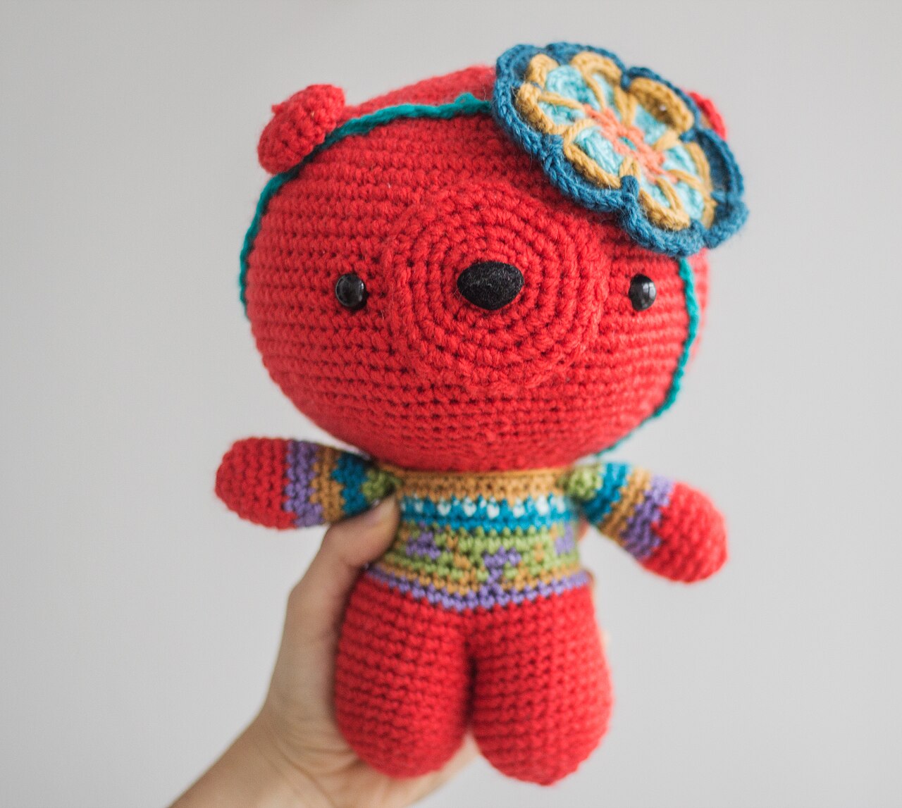 A crocheted amigurumi bear toy with classic round proportions and button eyes