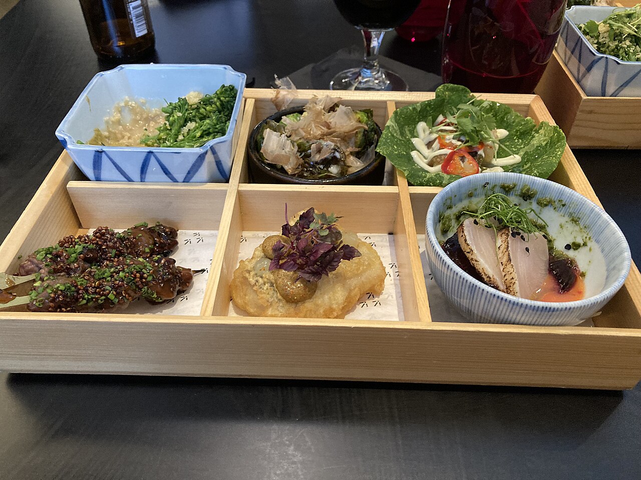 A beautifully arranged Japanese bento box with rice, vegetables, and protein in a divided lacquer container