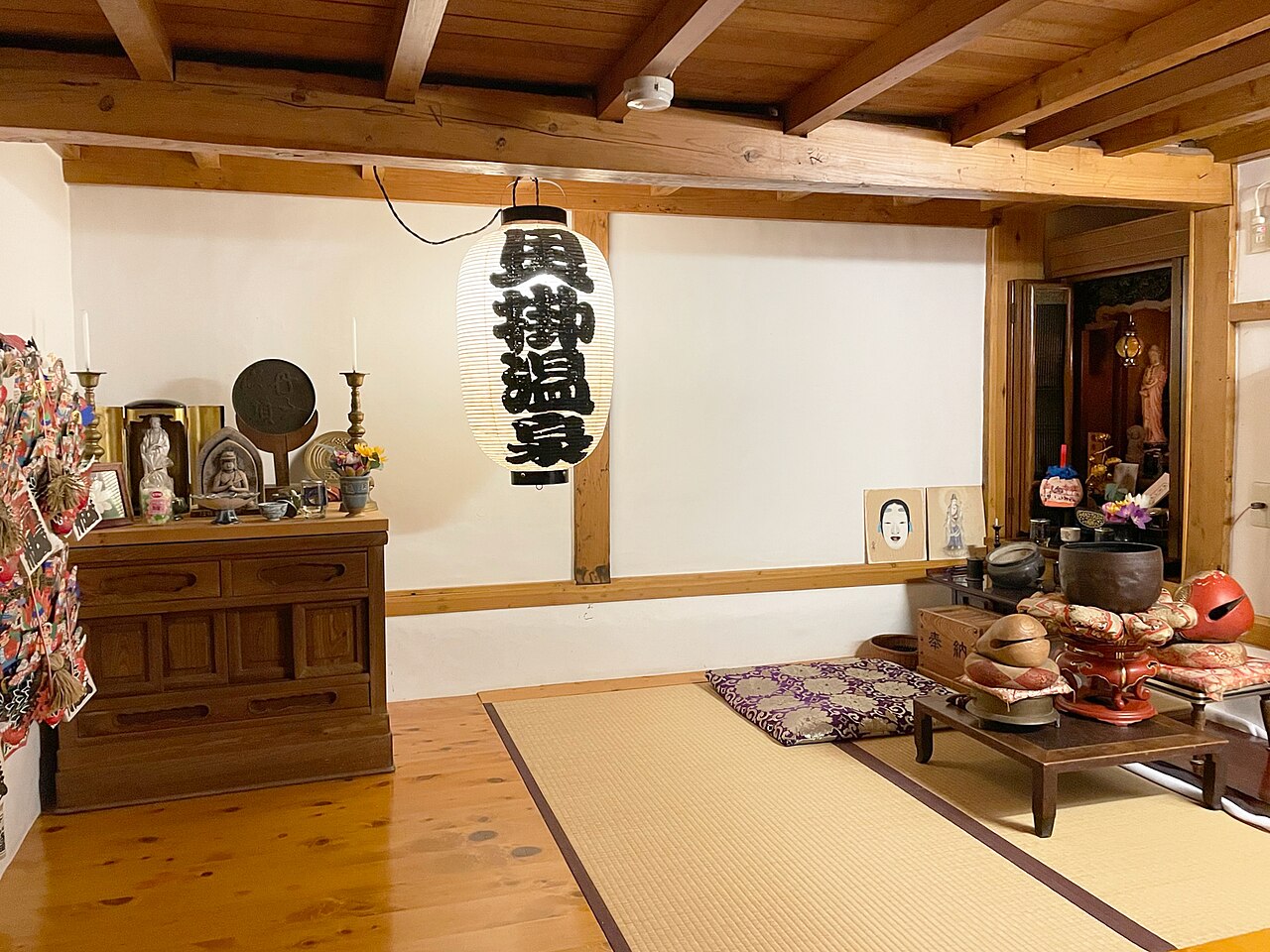 A butsudan altar room, with mortuary tablets, a Buddhist image, offering vessels, and photographs of the deceased