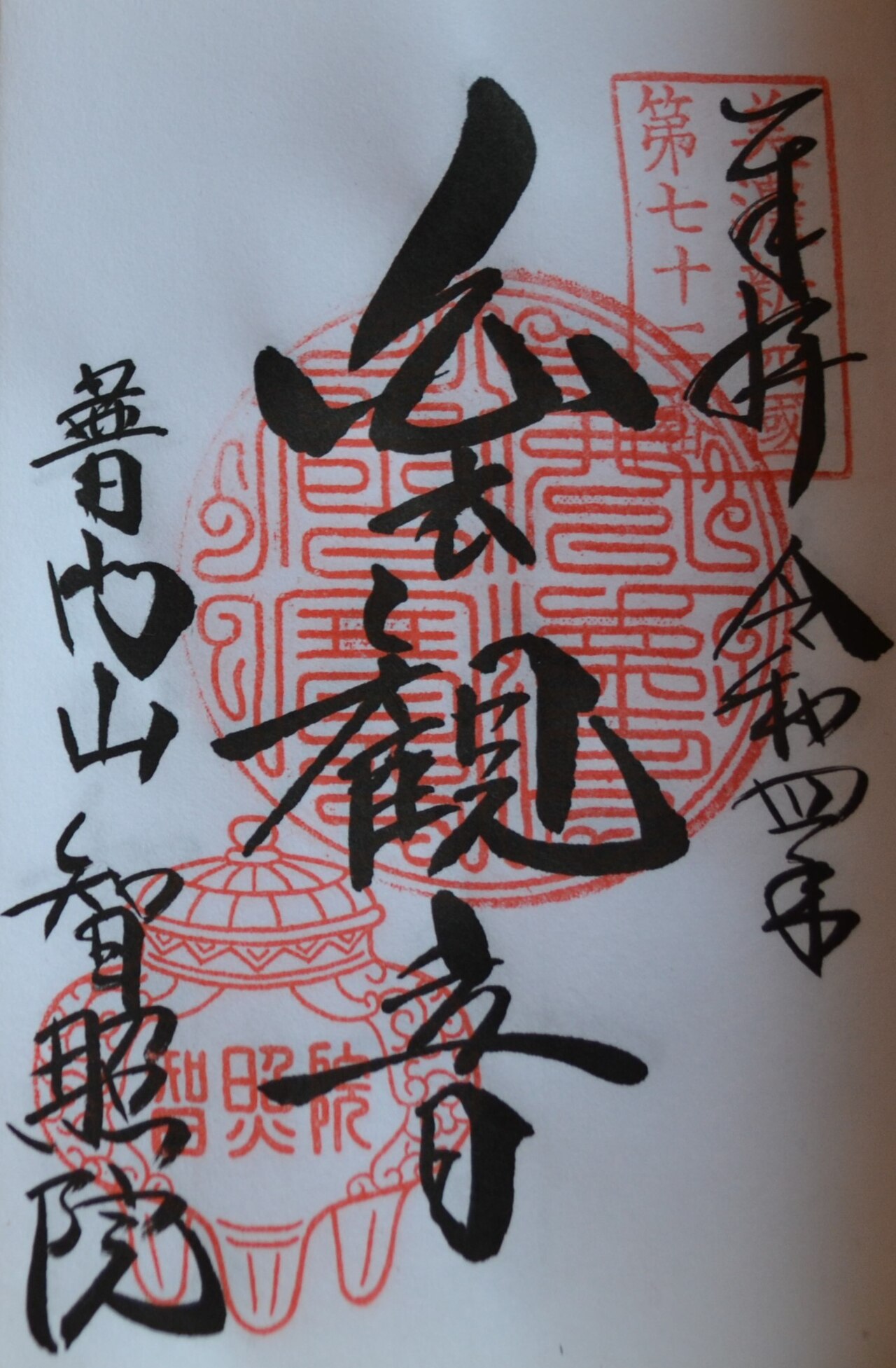 A hand-brushed goshuin combining red seals and black sumi-ink calligraphy