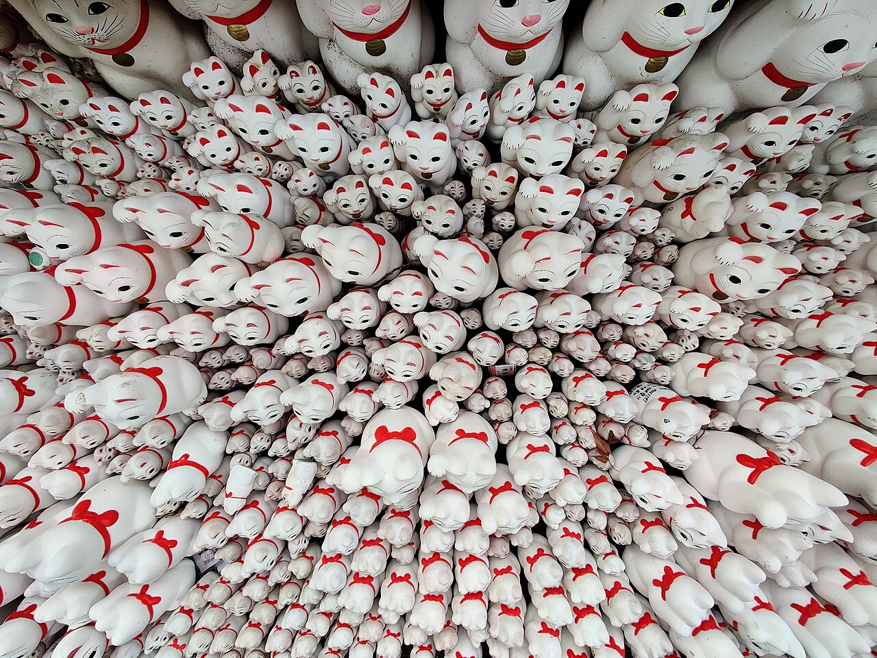 Hundreds of white maneki-neko figurines left as votive offerings at Gotokuji Temple in Tokyo