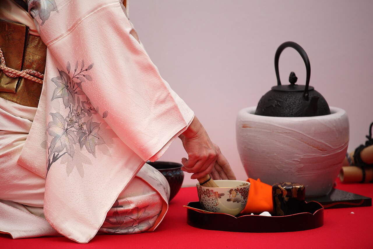 Hostess preparing matcha at an outdoor tea ceremony in Japan