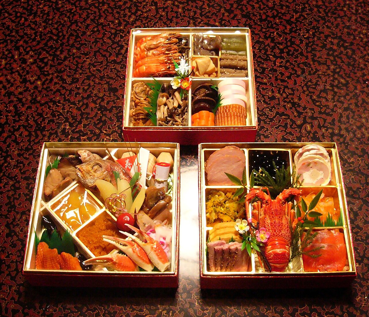 Osechi ryori arranged in stacked jūbako lacquer boxes with lobster, shrimp, and other New Year dishes