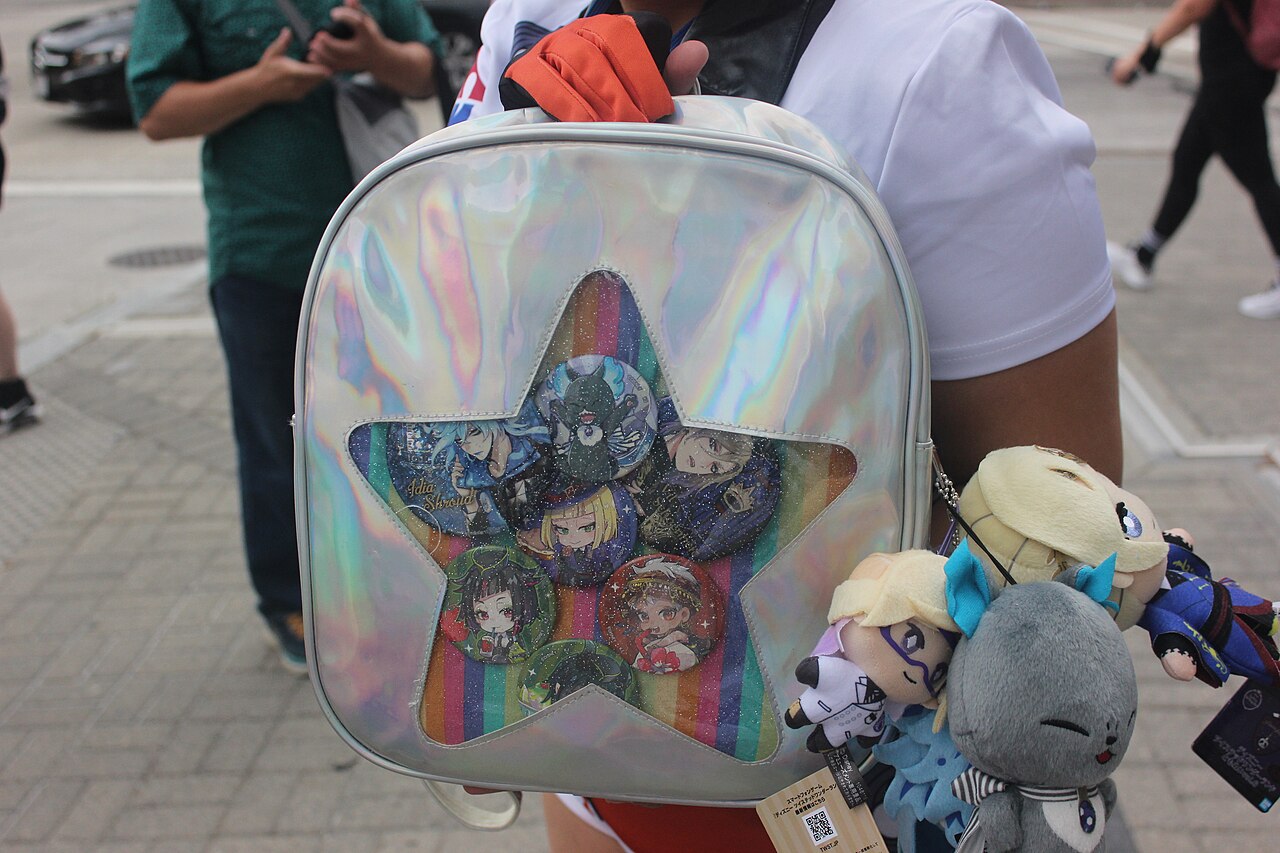 An ita-bag decorated with pin badges and charms of a favorite character