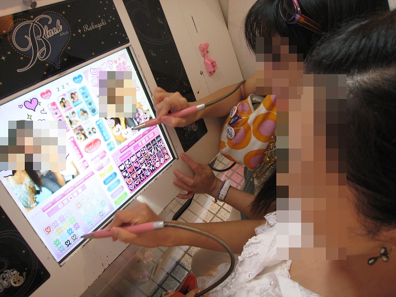 Women decorating photos on a purikura touchscreen in Osaka, 2007