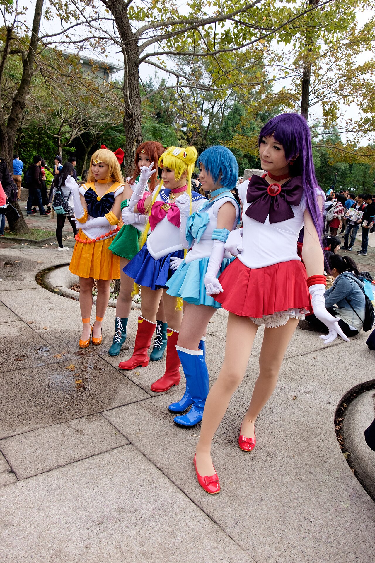 Cosplayers dressed as Sailor Moon and other Sailor Guardians posing together at a fan convention