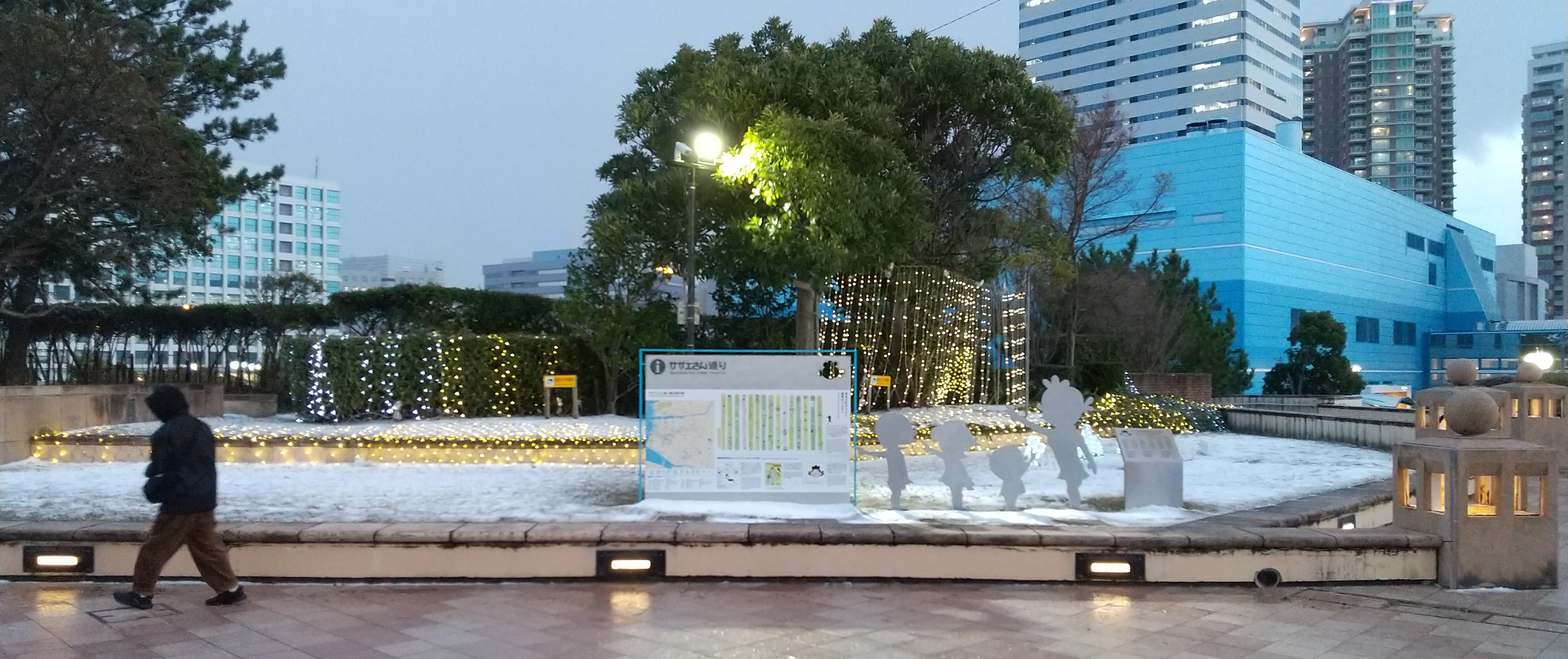 Signboard for Sazae-san-dōri ("Sazae-san Street") in Momochihama, Fukuoka, with silhouette statues of the Isono-Fuguta family